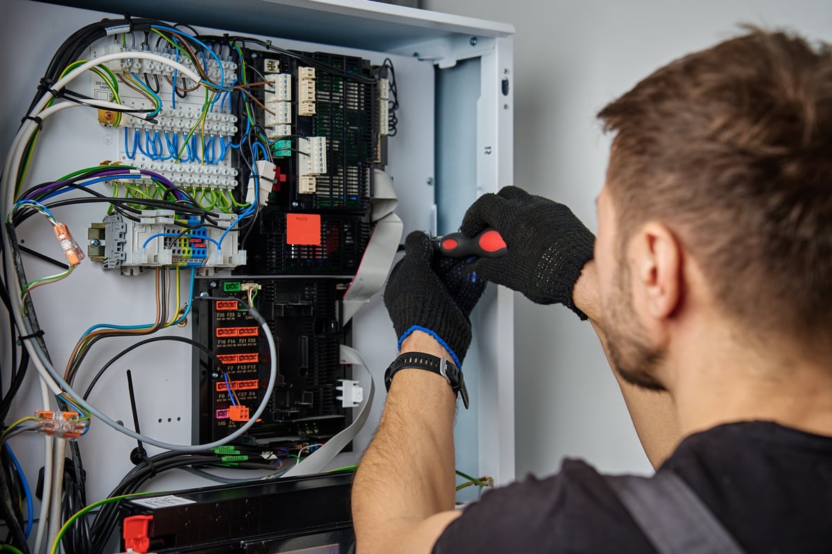 Technician working on electrical panel wiring