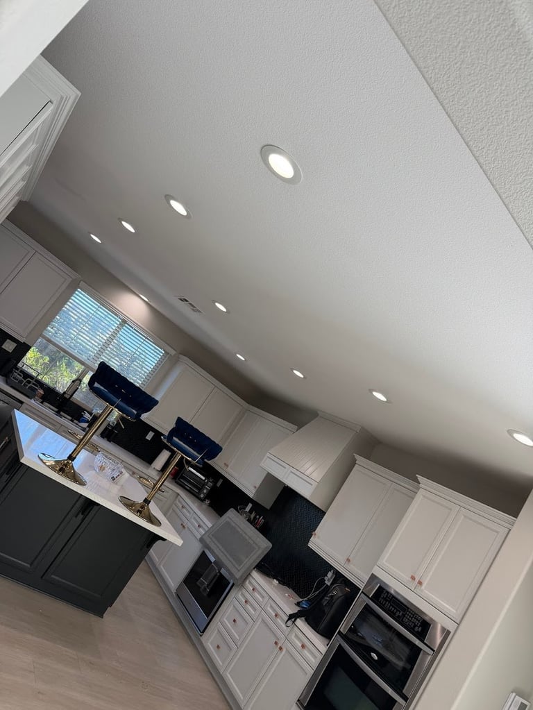 Modern kitchen interior with recessed ceiling lights, white and black cabinetry