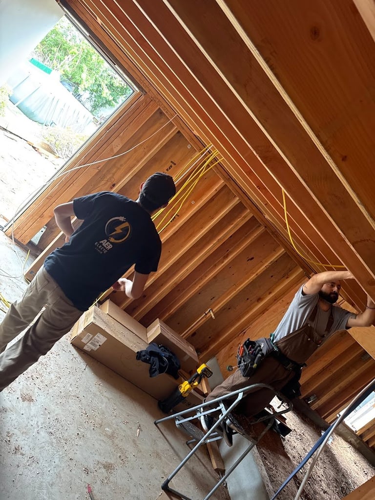 Two people working inside a wooden barn structure with exposed beams