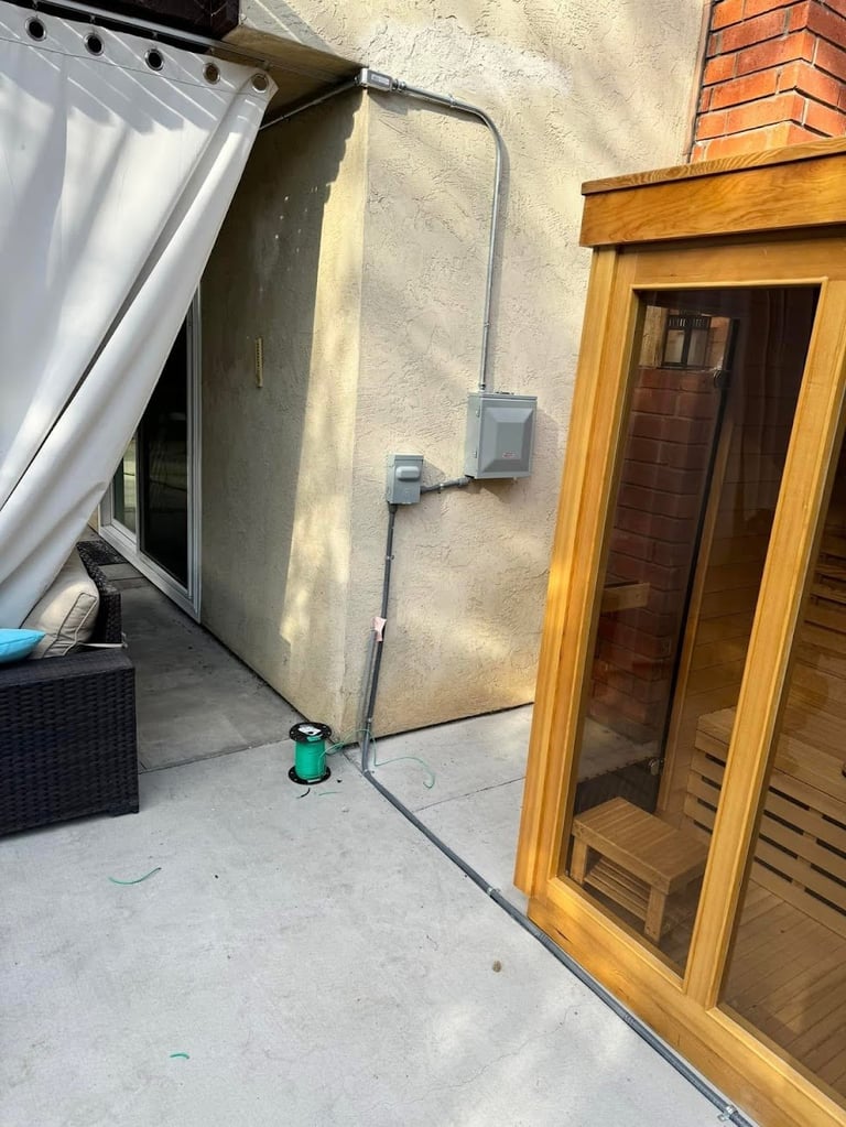 Residential patio with gray electrical conduit and water outlet
