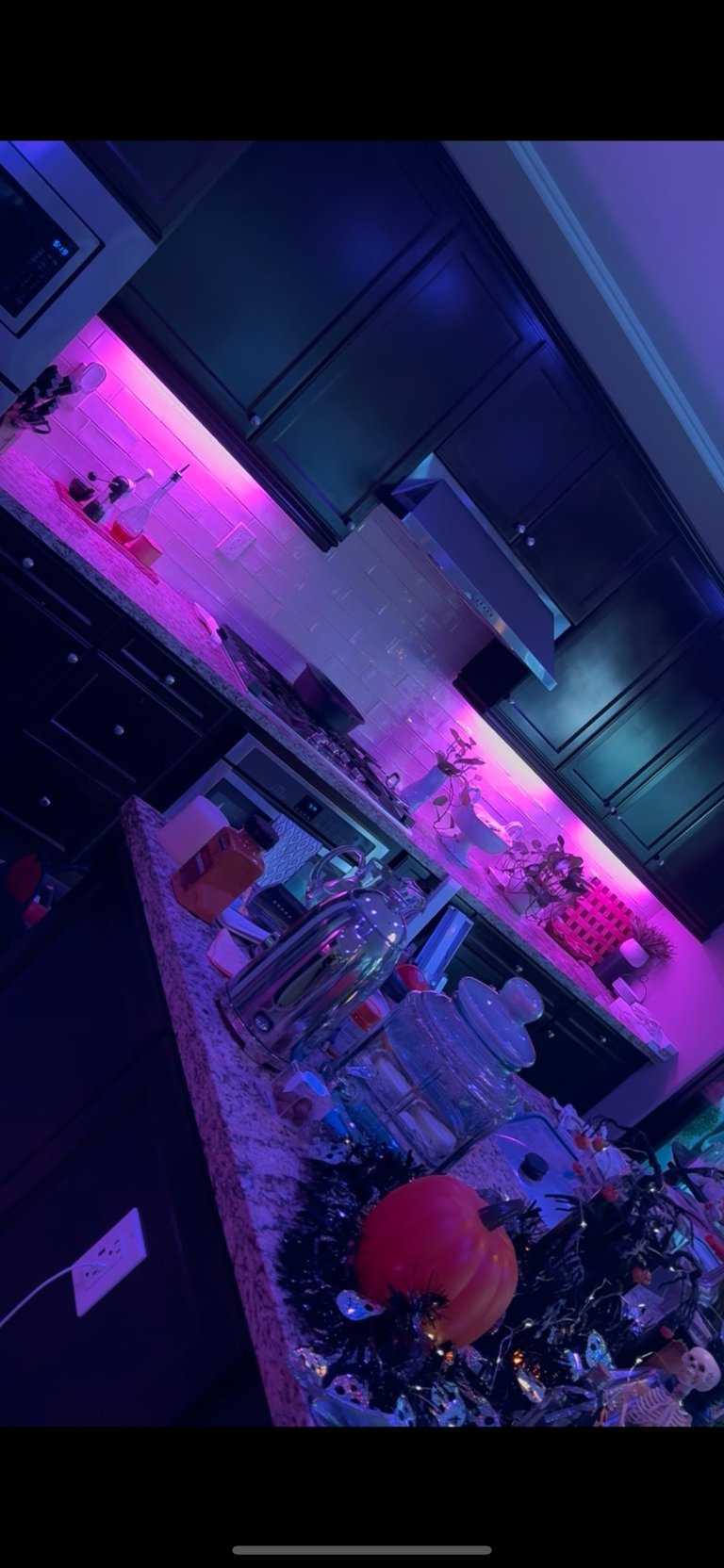 Neon-lit gaming setup and shelves with colorful merchandise displayed under magenta and blue lighting